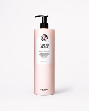 A bottle of Maria Nila Mirror Gloss Shampoo in a pale pink bottle with a black pump and white label, centered on a light gray background.