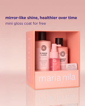 Maria Nila mini gloss coat gift set in a pink box, featuring a mirror-like shine gloss bottle, a glow cat pump bottle, and a free mini gloss coat card, with promotional text above on a pink gradient background.